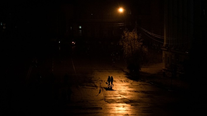 Kommunen - Stuttgart: Menschen laufen während einer Stromsperre in Kiew über eine Straße. Foto: Andrew Kravchenko/AP/dpa/Archivbild