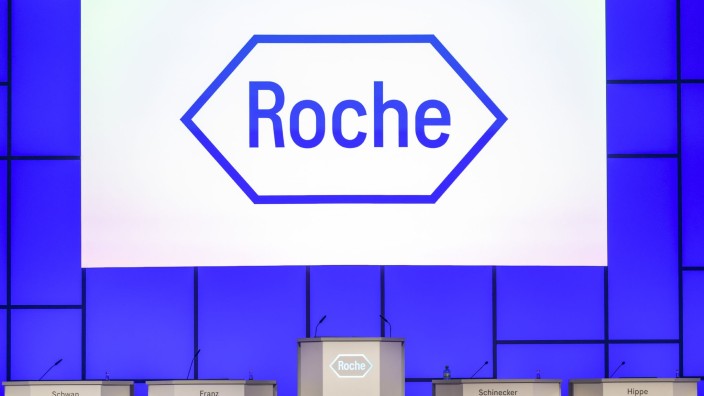 Pharma - Basel: Das Logo des Pharmaunternehmens Roche ist vor der Hauptversammlung auf der Bühne zu sehen. Foto: Georgios Kefalas/KEYSTONE/dpa