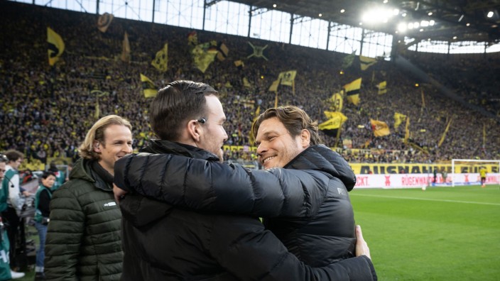 Fußball - Dortmund: Dortmunds Trainer Edin Terzic (r) begrüßt vor dem Spiel den ehemaligen BVB-Spieler Marcel Schmelzer (M). Foto: Bernd Thissen/dpa
