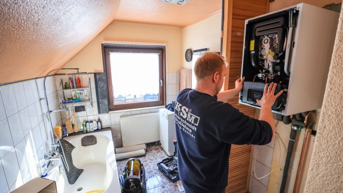 Energie - München: Ein Mitarbeiter einer Sanitär- und Heizungsbaufirma installiert eine moderne Gasbrennwerttherme in einem Einfamilienhaus. Foto: Jan Woitas/dpa/Symbolbild