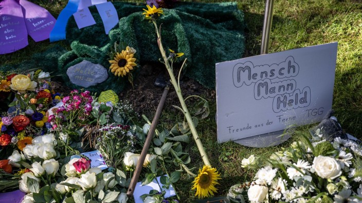 Kriminalität - Münster: Ein Plakat mit der Aufschrift "Mensch, Mann, Held" liegt neben Blumen am Grab des verstorbenen Malte C. bei Münster. Foto: Bernd Thissen/dpa/Archivbild