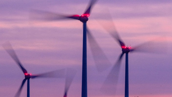 Energie - Dresden: Mit Signallampen beleuchtete Windräder drehen sich nach Sonnenuntergang. Foto: Jens Büttner/dpa/Archivbild