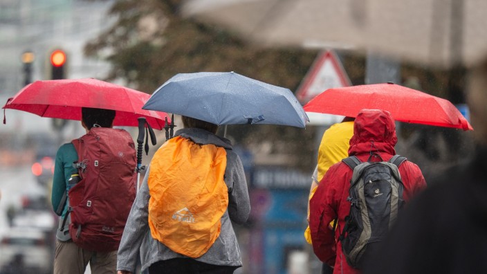 Wetter - Offenbach am Main: Menschen schützen sich bei Regen mit ihren Schirmen. Foto: Peter Kneffel/dpa/Symbolbild
