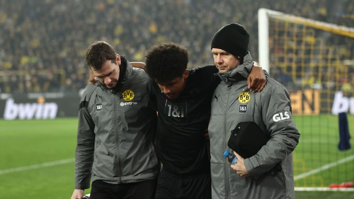 Fußball - Dortmund: Dortmunds Karim Adeyemi (M) wird vom Platz geführt. Foto: Rolf Vennenbernd/dpa