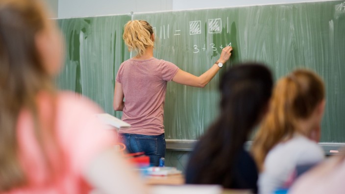 Bildung - Stuttgart: Eine Lehrerin schreibt im Mathematikunterricht einer achten Klasse an eine Schultafel. Foto: Julian Stratenschulte/dpa/Archivbild