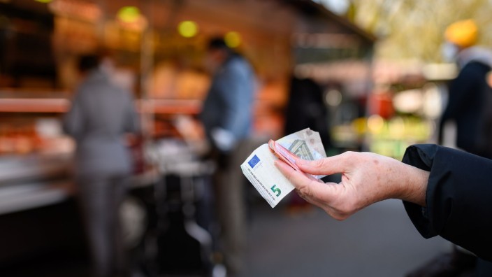 Einkommen - Fürth: Eine Frau hält Bargeld in der Hand. Foto: Jonas Walzberg/dpa/Symbolbild