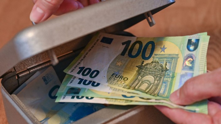 Einkommen - Halle (Saale): Eine Frau holt Eurobanknoten aus einer kleinen Geldkassette. Foto: Patrick Pleul/dpa-Zentralbild/dpa/Illustration