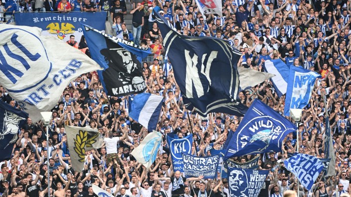 Fußball - Karlsruhe: Karlsruher Fans schwenken vor Spielbegin Fahnen. Foto: Uli Deck/dpa