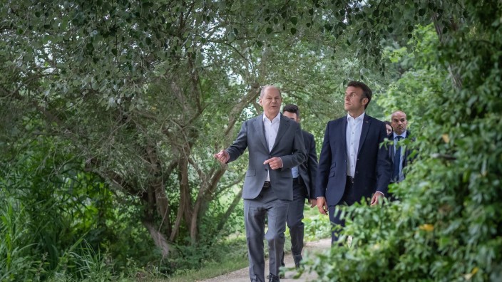 Diplomatie - Potsdam: Bundeskanzler Olaf Scholz (SPD, l) geht mit Emmanuel Macron, Präsident von Frankreich, zu einem gemeinsamen Abendessen. Foto: Michael Kappeler/dpa Pool/dpa