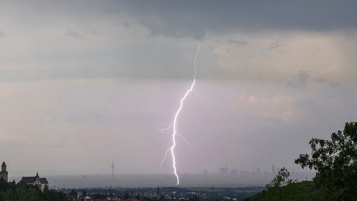 Wetter - Dieburg: Ein Blitz ist während eines Gewitters über der Skyline von Frankfurt am Main mit der Burg Kronberg (l) zu sehen. Foto: Jan Eifert/dpa