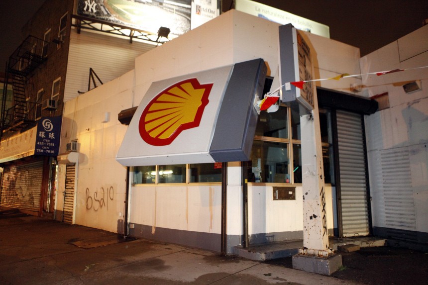 A Shell sign leans against the side of a gas station after it was knocked down due to a severe storm in Brooklyn