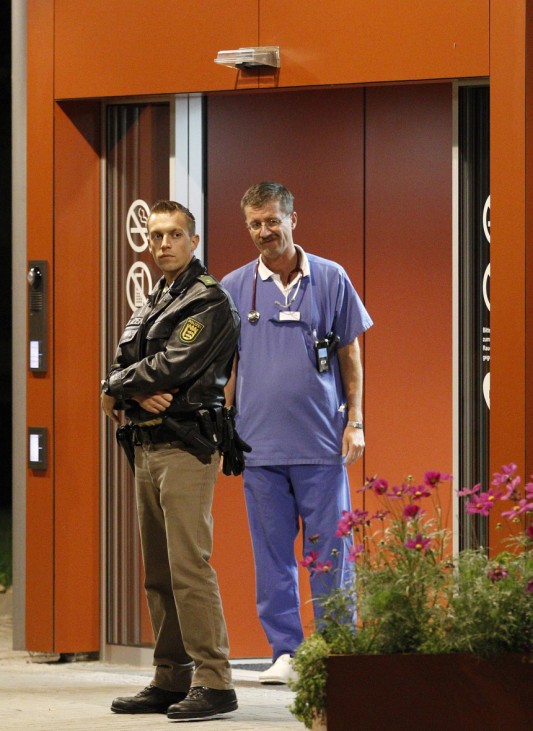 A policeman and a doctor stand in front of the main entrance of the St. Elisabethen-Krankenhaus hospital in the southern German town of Loerrach