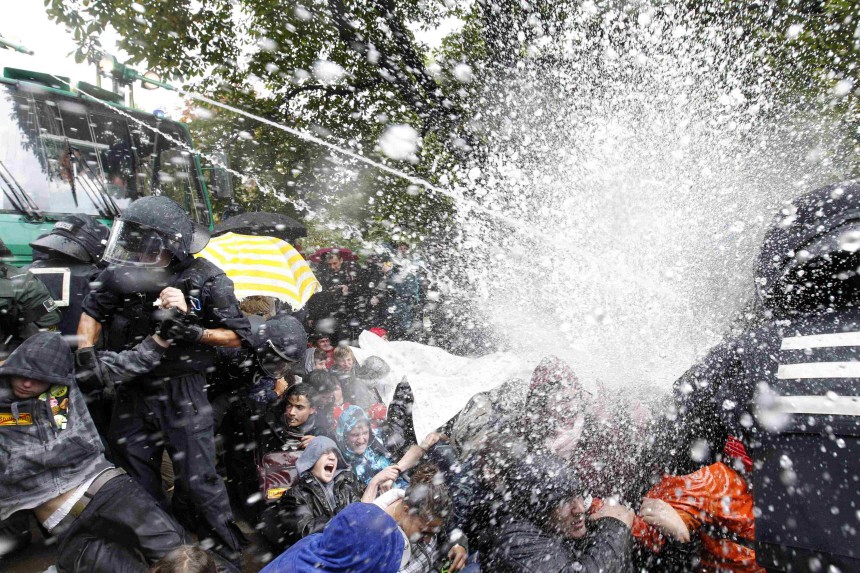 Policemen use water canons to remove protestors from a park next to the Stuttgart train station