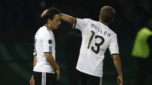Germany's Thomas Mueller (R) congratulates team mate Mesut Oezil after he scored a goal against Turkey during their Euro 2012 qualifying soccer match at the Olympic stadium in Berlin