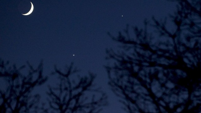 Mondsichel nahe der hellsten Planeten am Sternenhimmel Venus und Jupiter