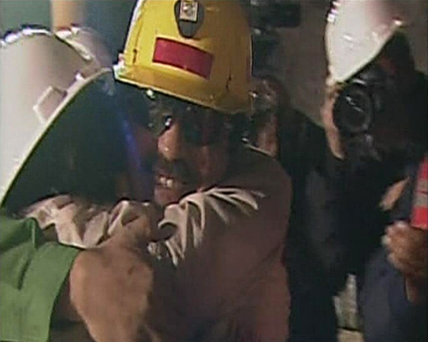 A frame grab shows Juan Illanes, the third of 33 workers trapped for more than two months in a Chilean mine, hugging his wife after reaching the surface above the San Jose mine in Copiapo