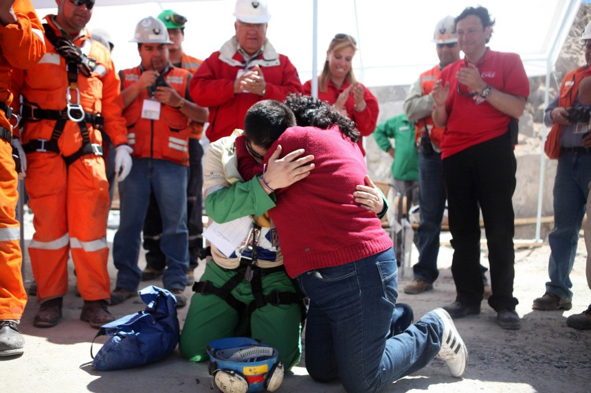 Trapped miner Rojas hugs his wife as he prays after reaching the surface to become the 18th to be rescued from the San Jose mine in Copiapo