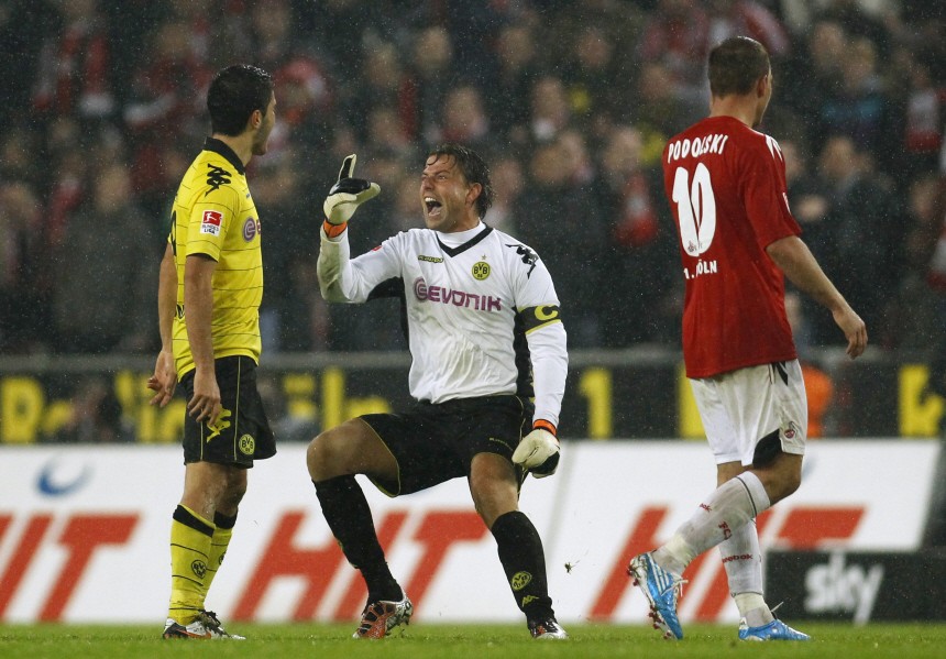 Borussia Dortmund's Weidenfeller and Sahin celebrate a goal, while Cologne's Podolski looks on during the German Bundesliga soccer match in Cologne