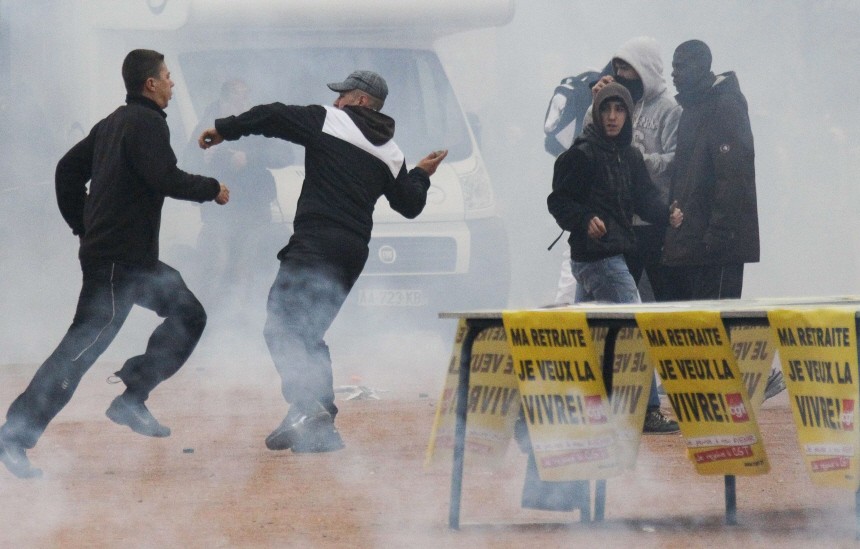 Youths clash with police during a demonstration over pension reform in Lyon