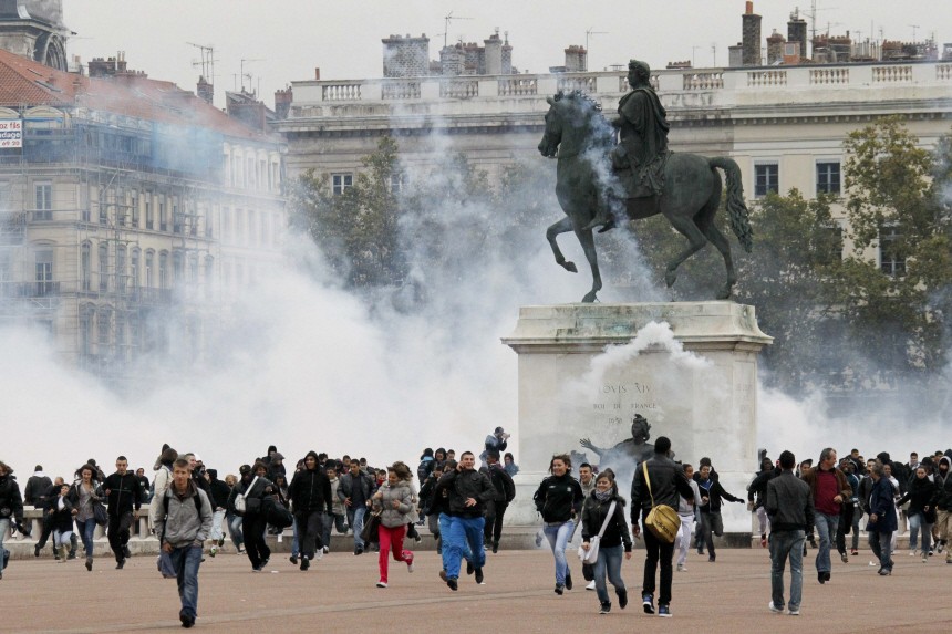 Youths clash with police at Place Bellecour during a demonstration over pension reform in Lyon