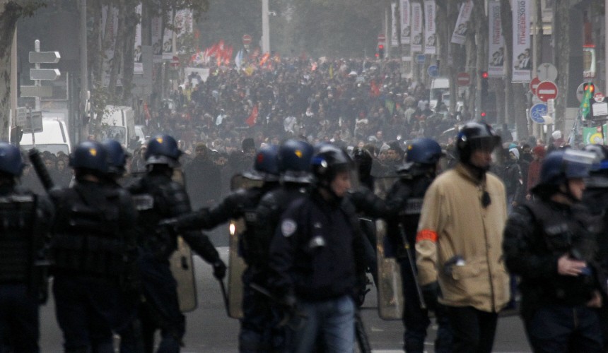 Youths face police during a demonstration over pension reform in Lyon