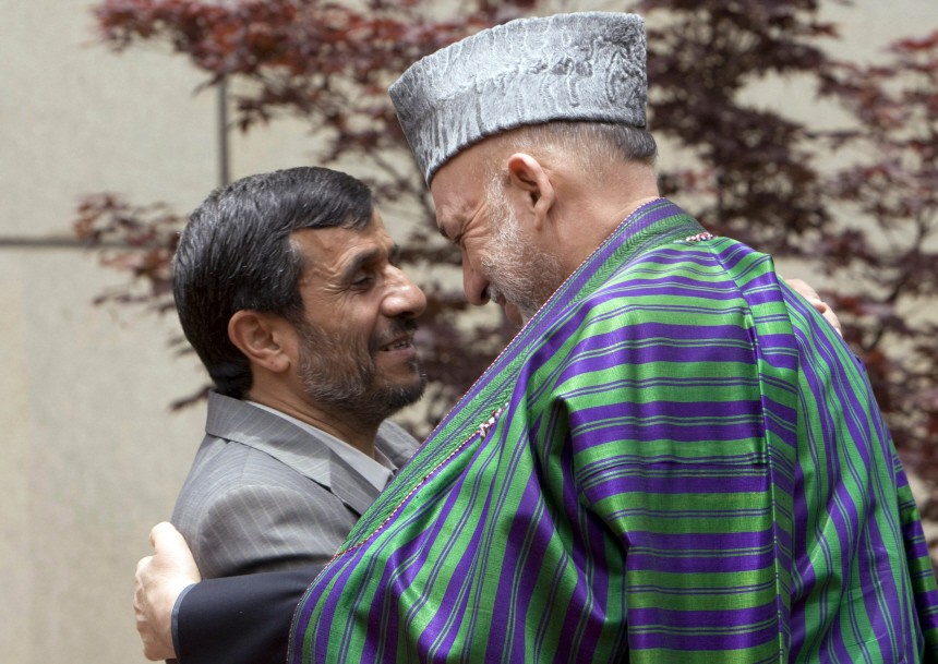 Iranian President Ahmadinejad greets Afghanistan's President Karzai before the start of a trilateral summit in Tehran