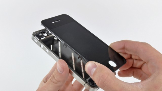 The front panel is removed from the iPhone 4 during iFixit's teardown of the phone in San Luis Obispo