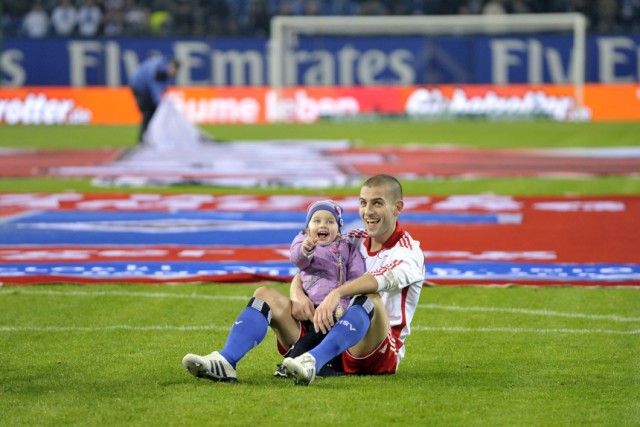 Hamburg SV's Petric smiles as his daughter gestures as they sit on pitch celebrating their victory after German Bundesliga first division soccer match against TSG Hoffenheim in Hamburg