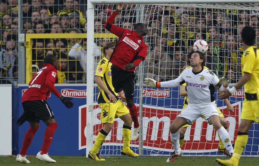 SC Freiburg's Cisse is challenged by Borussia Dortmund goalkeeper Weidenfeller during their German Bundesliga first division soccer match against in Freiburg