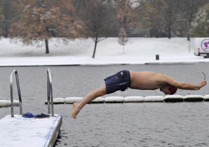 A swimmer dives into the Serpentine lake in Hyde Park in central London