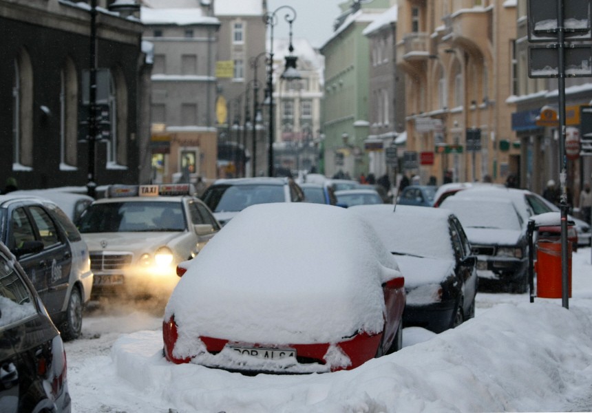 Cars covered in snow are pictured in the street in the centre of Poznan