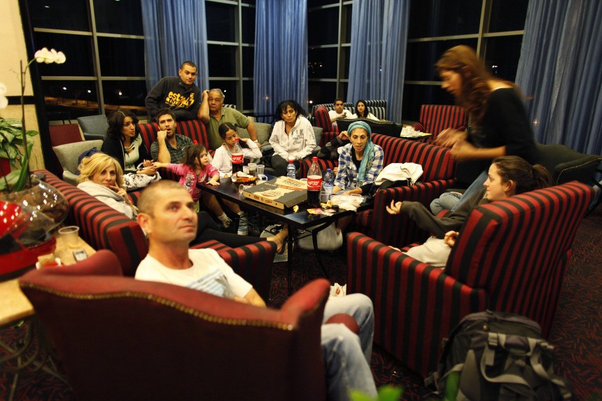People who were evacuated from their houses, rest in a hotel lobby in Haifa in the north of Israel