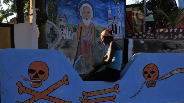Haitian woman waits for the start of a voodoo ceremony inside a voodoo temple during Day of the Dead celebrations in Belladere