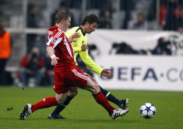 Abraham of FC Basel challenges Schweinsteiger of Bayern Munich during their UEFA Champions League match in Munich