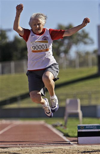 Canada's Olga Kotelko, 90, makes a leap while competing in the women's long jump during the Masters Games in Sydney Friday, Oct. 16, 2009. (AP Photo/Rick Rycroft)