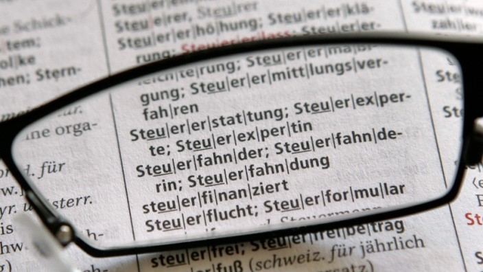 Sprachlabor (234): Eine Brille liegt auf einer Ausgabe des Dudens über den Begriffen rund um das Wort Steuer.