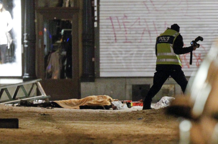 Police forensics expert examines the remains of a suspected suicide bomber in central Stockholm
