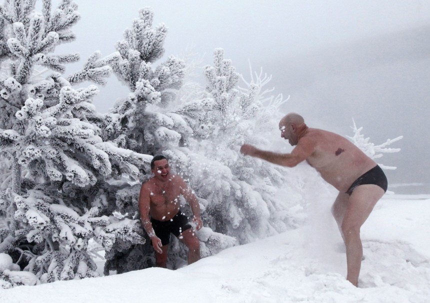 Members of a local winter swimmers' club play in the snow on the bank of the Yenisei River in Krasnoyarsk