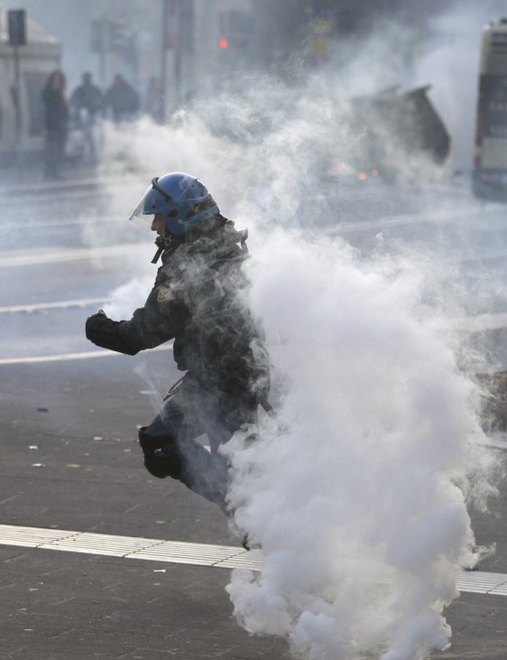 A riot policeman runs to take up position during anti-government clashes near the parliament in Rome