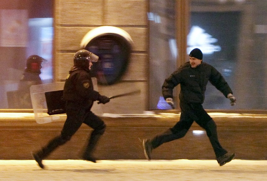 A riot policeman chases an opposition protester during a rally denouncing the results of presidential elections in central Minsk