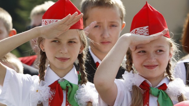 Belarussian schoolchildren salute during the Pioneer youth organisation's anniversary at Victory square in Minsk
