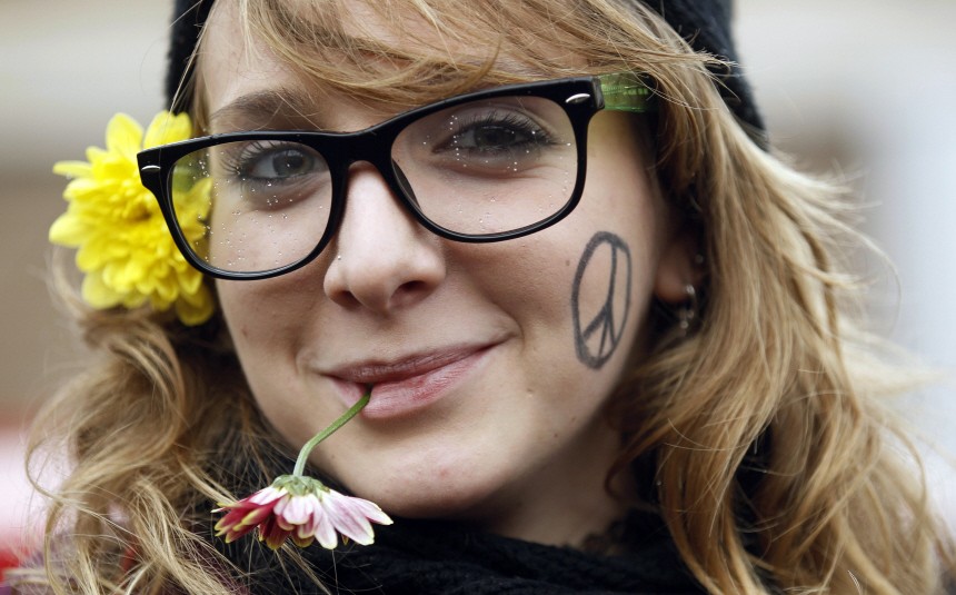A student biting on a flower smiles during a demonstration in Rome