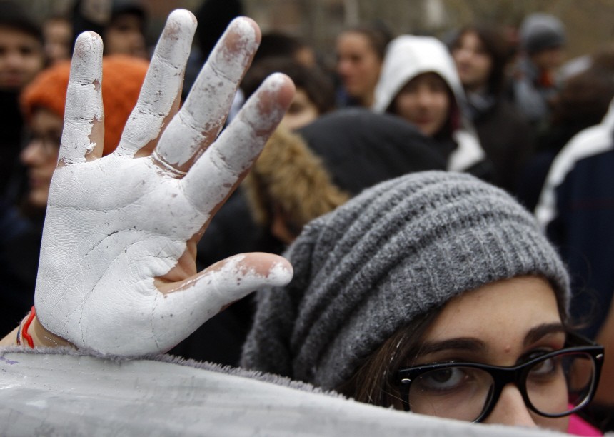 A student shows a hand painted in white during a demonstration in Rome