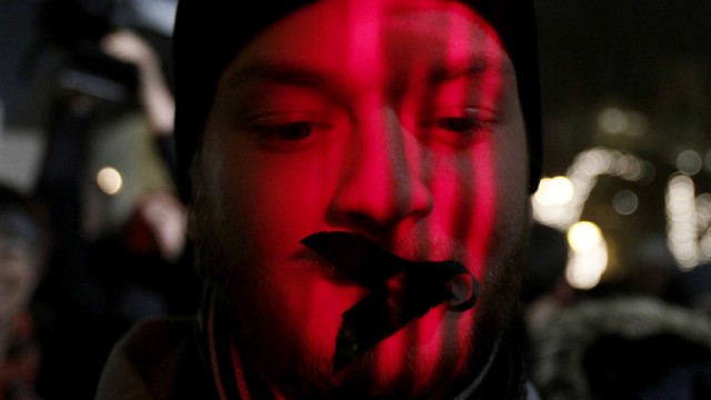 A protester wears tape over his mouth during a demonstration against a new media law in downtown Budapest