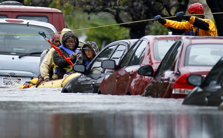 Emergency water rescue crew members ferry guests from their hotel after heavy rains and flooding trapped them in San Diego