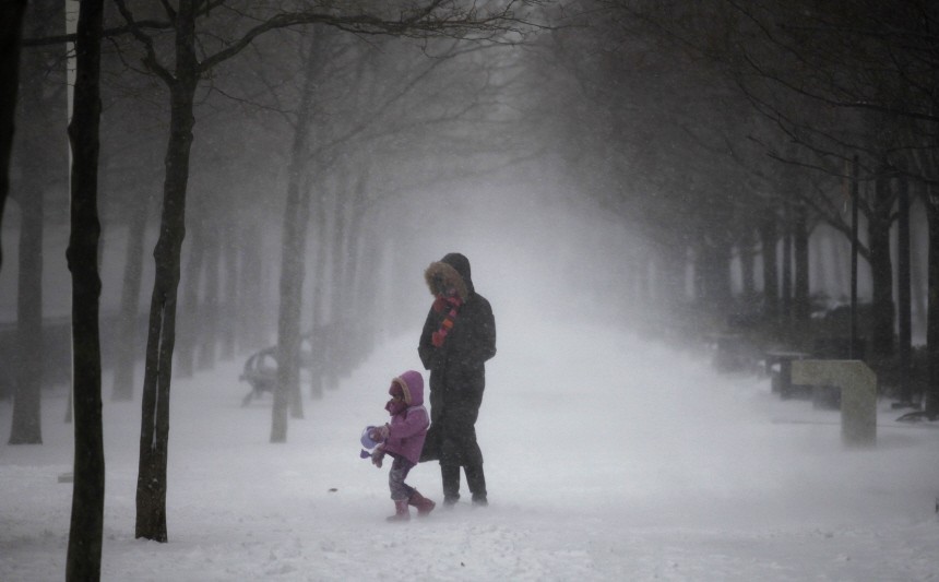 A mother walks with her daughter along a snow covered walkway in Hoboken