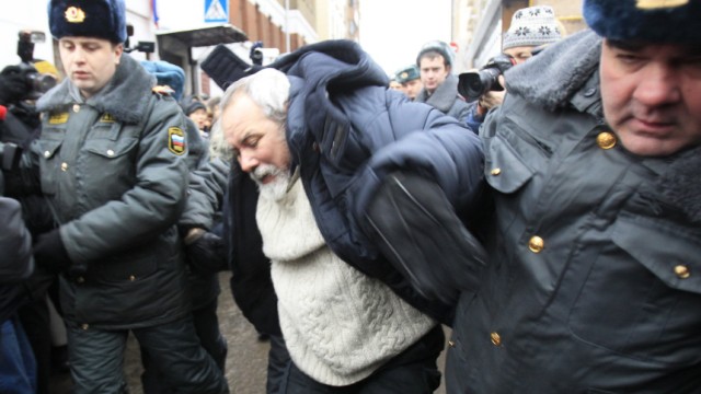 Police officers detain a man during a rally to support Khodorkovsky in front of the court building in Moscow