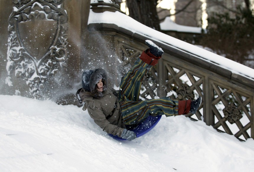 A woman sleds down a flight of snow covered stairs in New York's Central Park