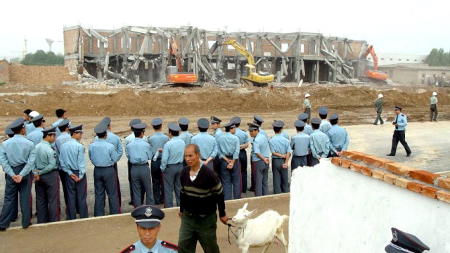 Bau-Boom in China: Chinesische Polizisten sind aufmarschiert, um den Abriss von illegal errichteten Häusern zu bewachen. An solchen Bauprojekten bereichern sich oft örtliche Kader der Kommunistischen Partei.