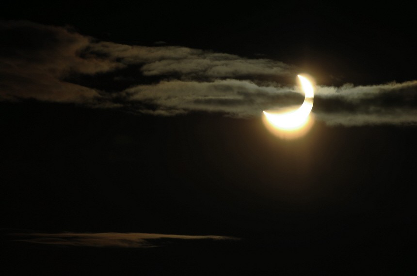 A partial solar eclipse is seen through clouds over Stockholm